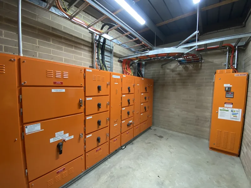 Lineup of orange industrial switchboards in a plant room